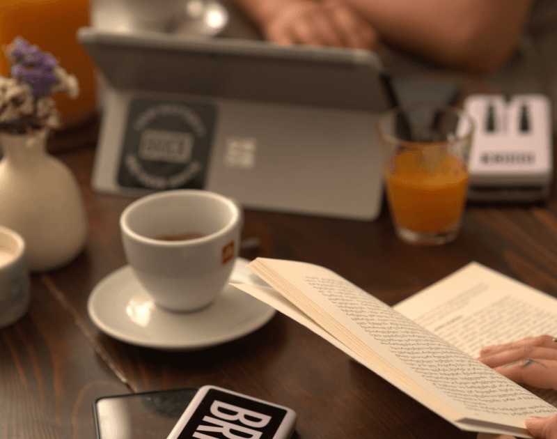 Femme lisant un livre tout en rechargeant son téléphone avec une brique